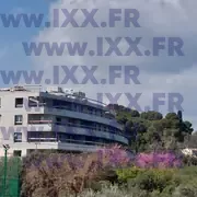 Bâtiment béton construction balcons courbés arbres environnants 03.2026
