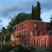 Façade rénovée avec balcons et terrasses intégrés dans un cadre résidentiel méditerranéen paisible.