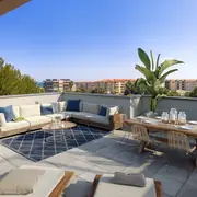 Grande terrasse aménagée avec mobilier pour détente et repas en plein air.