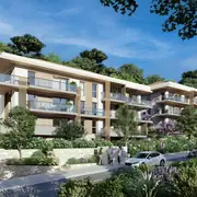 Bâtiments modernes avec balcons en verre, entourés de jardins paysagers.