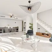 Espace de vie ouvert et aménagé avec canapé confortable et lumière naturelle abondante.
