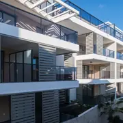 Bâtiment avec balcons modernes et façades épurées intégrées dans le paysage urbain.