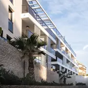 Accès sécurisé entouré d'espaces verts et plantations soignées pour un environnement apaisant.