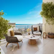 Terrasse avec mobilier design offrant des vues sur la mer à proximité de la résidence.
