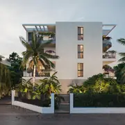 Bâtiment résidentiel de faible hauteur entouré de végétation, architecture moderne et épurée.