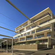 Aspect extérieur contemporain avec balcons en verre et volets intégrés.