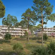 Immeubles discrets intégrés dans un cadre naturel protégé de Sophia Antipolis, avec végétation abondante.