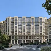 Façade du bâtiment illustrant les influences Belle Époque avec verrières et balcons.