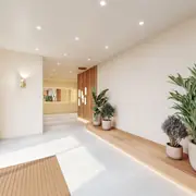 Espace d'entrée aux teintes claires alliant matériaux nobles et design épuré pour un accueil chaleureux.