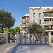 Entrée principale sécurisée mêlant ferronnerie moderne et murets traditionnels au cœur d'aménagements paysagers soignés.