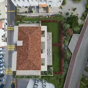 Perspective aérienne montrant l'implantation du bâtiment et les espaces verts paysagers.